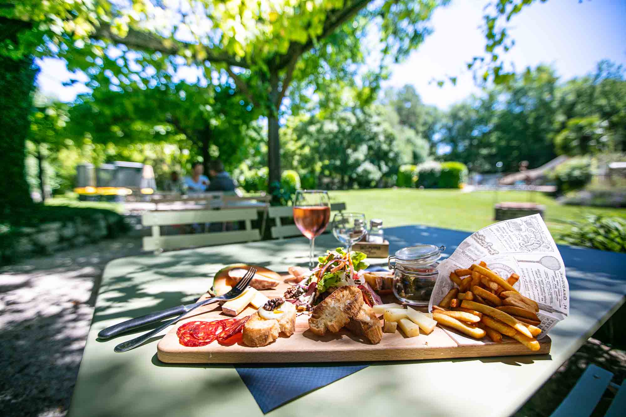 Planche de charcuterie et vin rosé local sous une pergola, gastronomie régionale